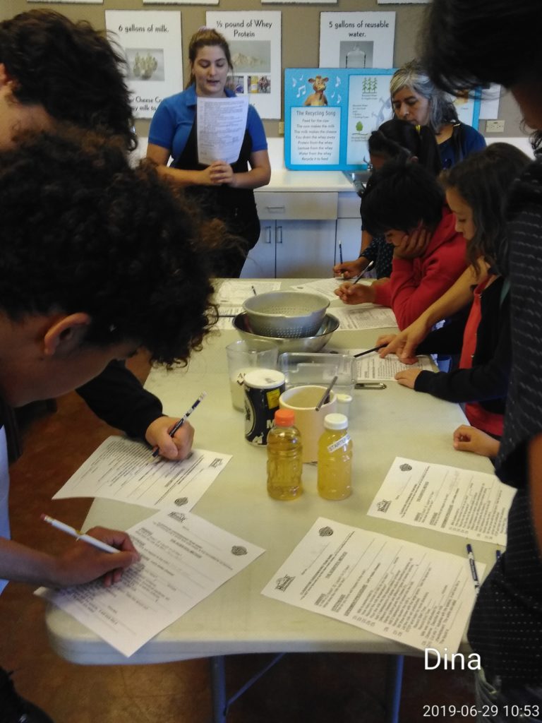 A group of people sitting at a table writing on paper.