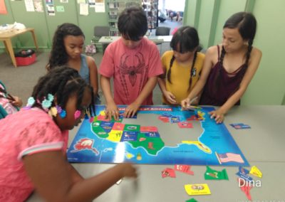 A group of children playing with an interactive map.