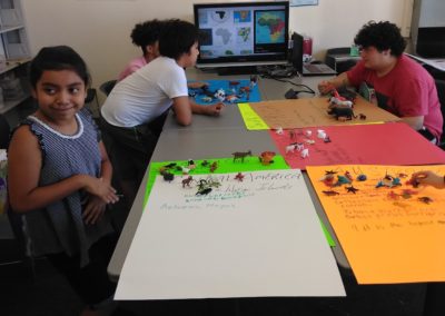 A group of children sitting at a table with legos.