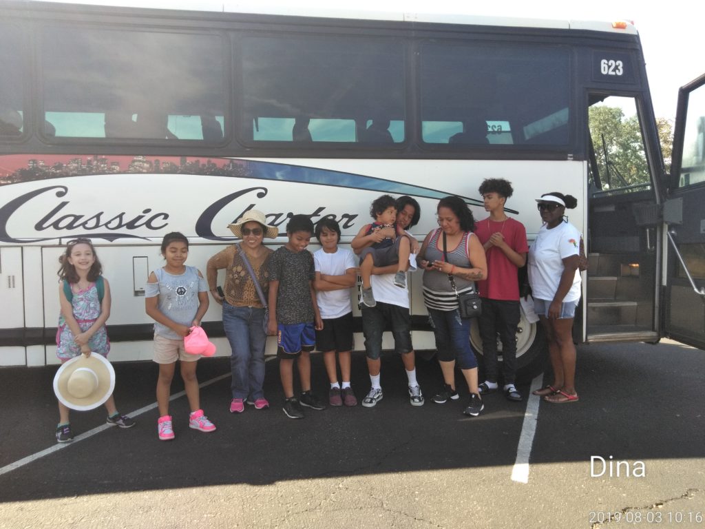 A group of people standing in front of a bus.