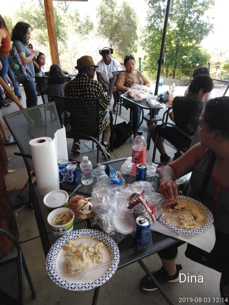 A group of people sitting at tables eating food.